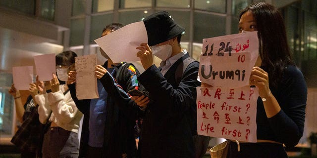 Protesters hold up white paper some with writings commemorating the Nov. 24 deadly Urumqi fire during a gathering at the University of Hong Kong, Tuesday, Nov. 29, 2022.