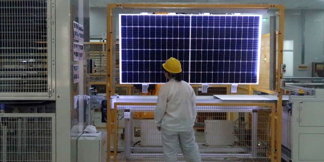 A worker quality checks a solar component in China. Imports from its Xinjiang region have been suspended over concerns of slave labor.