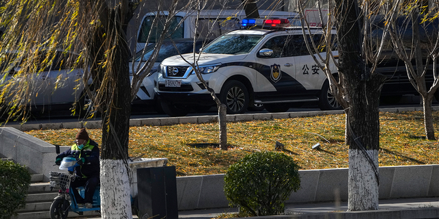 A police vehicle patrols along the riverbank near the site of last weekend's protest in Beijing.