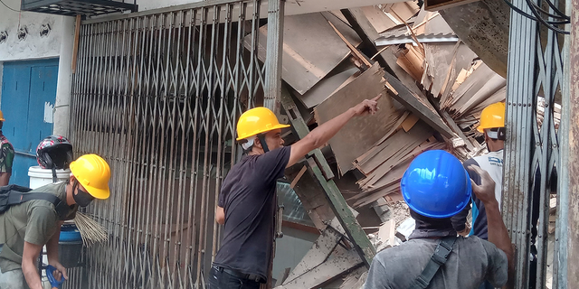 Workers inspect a shop damaged during an earthquake in Cianjur, West Java, Indonesia, Monday, November 21, 2022.