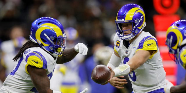 Matthew Stafford of the Los Angeles Rams, right, hands the ball off to Darrell Henderson Jr. during the first quarter against the New Orleans Saints at Caesars Superdome Nov. 20, 2022, in New Orleans.