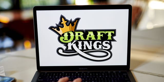 The logo for DraftKings is displayed on a laptop computer in an arranged photo taken in Little Falls, New Jersey, US, on Wednesday, October 7, 2020.  The 19 infections in the National Football League sent shares of the online gaming company plunging this week.