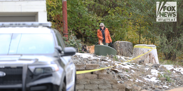 Investigators use a K-9 to search a home where four college students were killed over the weekend in Moscow, Idaho. 