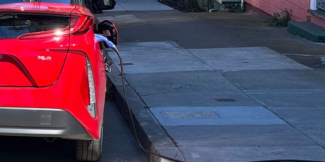 An electric vehicle is being charged on the side of a road in San Francisco, California, on Sept. 23, 2022.
