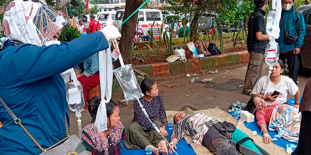 People injured in an earthquake are seen at a hospital parking lot in Cianjur, West Java, Indonesia on Monday, April 11, 2022.