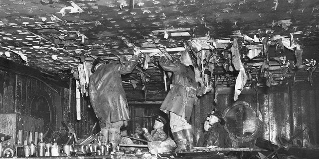 Chairs are knocked over and the bar is littered with broken bottles as people inspect the Lounge Bar on the Broadway Street side of the Cocoanut Grove nightclub in Boston on Nov. 29, 1942, after a fire that killed nearly 500 and injured hundreds more. 