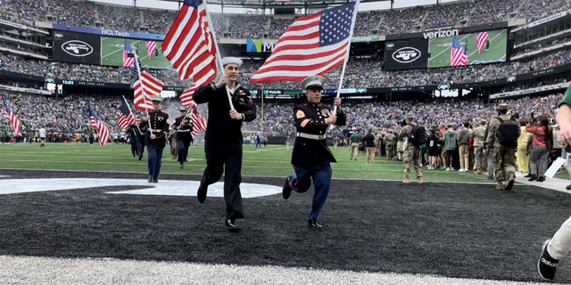 Military service members rush the field at MetLife Stadium in New Jersey during the New York Jets' Salute to Service game on Nov. 6, 2022.