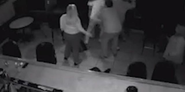 A still frame from surveillance video shows a crowd around a man who opened fire in a Florida bar.