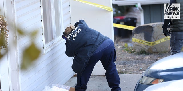 Investigators taking pictures outside the home where four students were killed. 