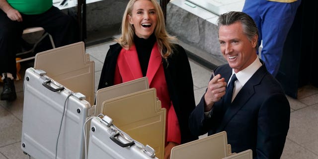 Democrat California Gov. Gavin Newsom stands with wife Jennifer at a Sacramento voting center. Newsom's administration is expected to contend with rising cost of living, crime, and homelessness concerns.