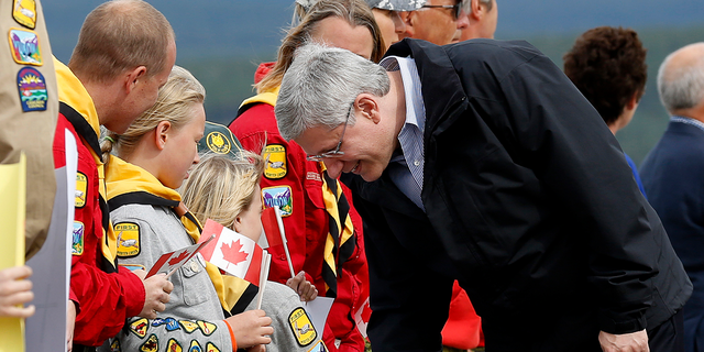 Former Canadian Prime Minister Stephen Harper greets local Girl Guides after arriving in Whitehorse, Yukon, Aug. 18, 2013. Harper is taking part in his annual tour of Northern Canada.