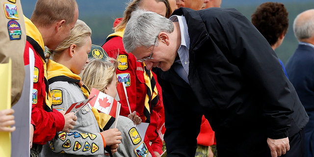 Former Canadian Prime Minister Stephen Harper greets local Girl Guides after arriving in Whitehorse, Yukon, Aug. 18, 2013. Harper is taking part in his annual tour of Northern Canada.