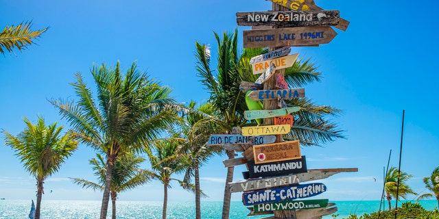 Direction signpost on the Long Bay Beach, on the southeast side of Providenciales in the Turks and Caicos Islands.