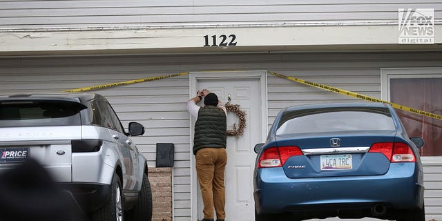 Un investigador cierra con cinta adhesiva una puerta en la casa en Moscow, Idaho, el martes 22 de noviembre de 2022, donde cuatro personas fueron asesinadas el 13 de noviembre.