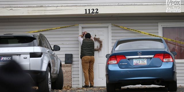 Un investigador cierra con cinta adhesiva una puerta en la casa en Moscow, Idaho, el martes 22 de noviembre de 2022, donde cuatro personas fueron asesinadas el 13 de noviembre.