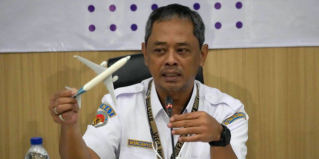 National Transportation Safety Committee investigator Nurcahyo Utomo holds an airplane model during a press conference in Jakarta, Indonesia, on Nov. 10, 2022. 