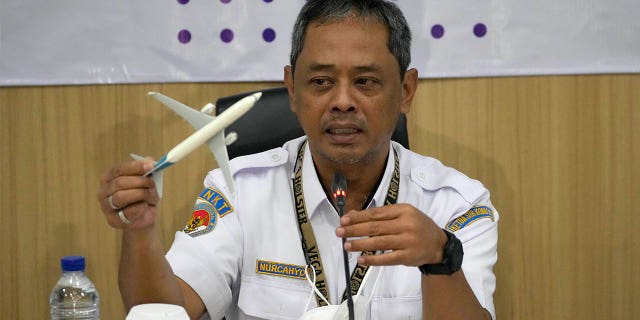 National Transportation Safety Committee investigator Nurcahyo Utomo holds an airplane model during a press conference in Jakarta, Indonesia, on Nov. 10, 2022.