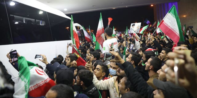 Iranian fans wave flags as they gather at Imam Khomeini Airport in Tehran Dec. 1, 2022, to greet the Iranian national team upon its return after competing in the Qatar 2022 World Cup.