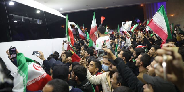 Iranian fans wave flags as they gather at Imam Khomeini Airport in Tehran Dec. 1, 2022, to greet the Iranian national team upon its return after competing in the Qatar 2022 World Cup. 