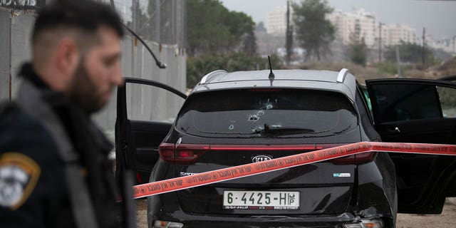 Israeli police cordon off the car belonging to a Palestinian man that rammed into an Israeli soldier, seriously injuring her, before he was shot dead by Israeli police near the Israeli settlement of Kochav Yakov, in the occupied West Bank, on Nov. 29, 2022.