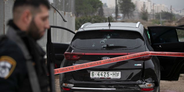 Israeli police cordon off the car of a Palestinian man who crashed into an Israeli soldier, seriously injuring her, before being shot dead by Israeli police near the Israeli settlement of Kochav Yakov in the occupied West Bank on 29 November 2022. .