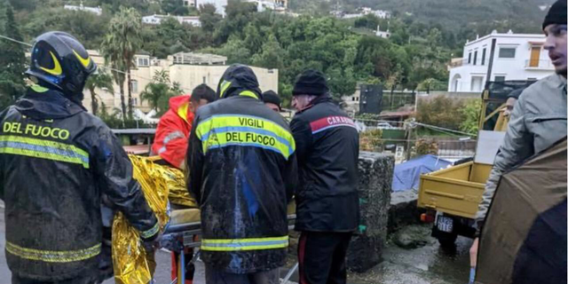 Rescuers help an injured person following a landslide on the Italian holiday island of Ischia, Italy, in this handout photo obtained by Reuters on Nov. 26, 2022. 