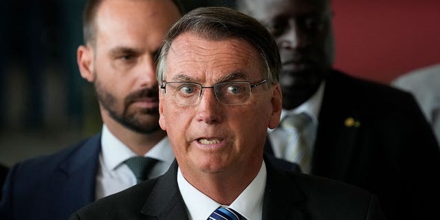 Brazilian President Jair Bolsonaro speaks from his official residence of Alvorada Palace in Brasilia, Brazil, Tuesday, Nov. 1, 2022, the leader's first public comments since losing the Oct. 30 presidential runoff. Behind his Bolsonaro's son Eduardo, a lawmaker. 