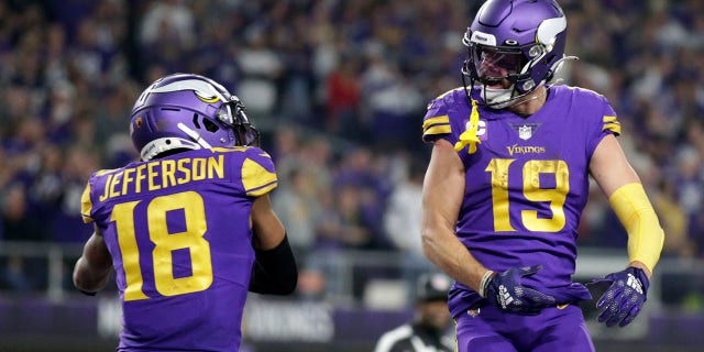 Le receveur large des Vikings du Minnesota Adam Thielen (19 ans) célèbre avec son coéquipier le receveur large Justin Jefferson (18 ans) après avoir attrapé une passe de touché de 15 verges lors de la seconde moitié d'un match de football de la NFL contre les Patriots de la Nouvelle-Angleterre, le jeudi 24 novembre 2022, à Minnéapolis. 