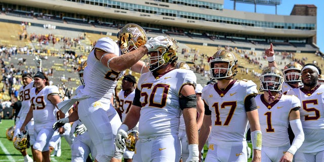 Wide receiver Brock Annexstad #81, offensive lineman John Michael Schmitz #60 and their Minnesota Golden Gophers teammates walk off the field after a 30-0 win over the Colorado Buffaloes at Folsom Field on September 18, 2021 in Boulder, Colorado. 