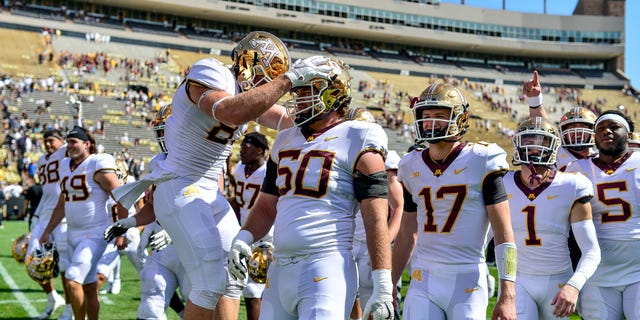 Wide receiver Brock Annexstad #81, offensive lineman John Michael Schmitz #60 and their Minnesota Golden Gophers teammates walk off the field after a 30-0 win over the Colorado Buffaloes at Folsom Field on September 18, 2021 in Boulder, Colorado.
