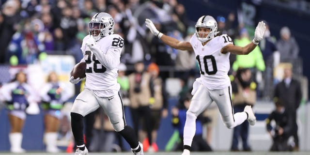 Josh Jacobs (28) of the Las Vegas Raiders runs with the ball in overtime against the Seattle Seahawks at Lumen Field on Nov. 27, 2022, in Seattle, Washington.