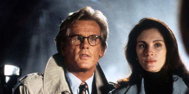 Nick Nolte and Julia Roberts standing next to each other in a scene from the film "I Love Trouble," in 1994.