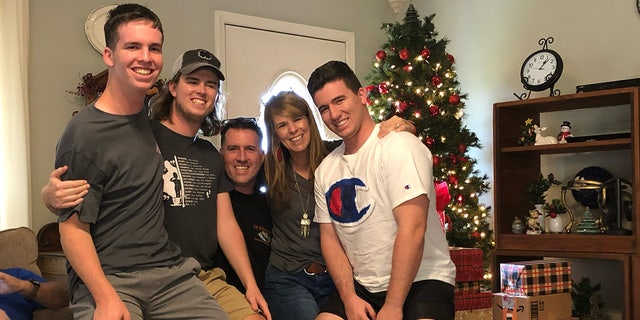 Katherine McClanahan, her husband and their three sons crowd together for a family photo. McClanahan said she has suffered long-lasting symptoms after drinking fuel-contaminated water in Hawaii.