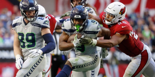 Zaven Collins #25 of the Arizona Cardinals tackles Kenneth Walker III #9 of the Seattle Seahawks during the fourth quarter of the game at State Farm Stadium on November 06, 2022 in Glendale, Arizona.