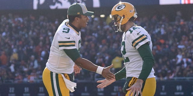 Green Bay Packers quarterbacks DeShone Kizer (9) and Aaron Rodgers (12) shake hands on the field during a game against the Chicago Bears on December 16, 2018 at Soldier Field in Chicago.