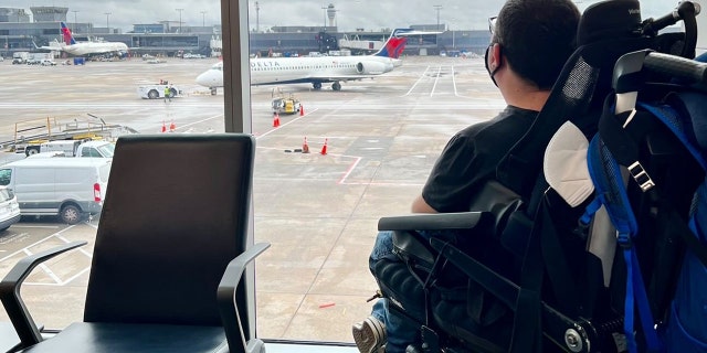 Cory Lee looks out a window at Hartsfield-Jackson Atlanta International Airport in Atlanta.