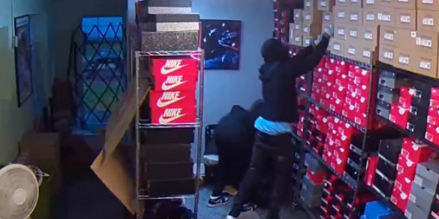 Surveillance video shows the suspects rummaging through shoe boxes at Laced Connection in Fort Worth, Texas.