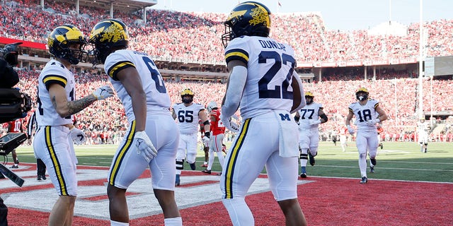 Michigan's Cornelius Johnson, center, celebrates with teammates after his touchdown against Ohio State during the first half of a game Saturday, Nov. 26, 2022, in Columbus, Ohio