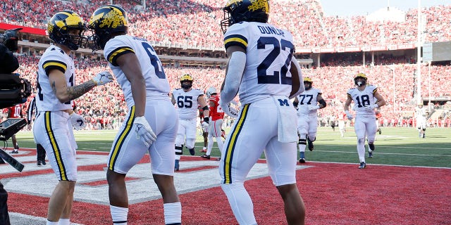 Michigan's Cornelius Johnson, center, celebrates with teammates after his touchdown against Ohio State during the first half of a game Saturday, Nov. 26, 2022, in Columbus, Ohio