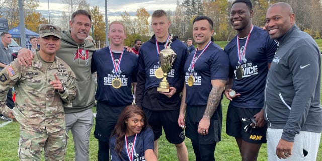 Former Tampa Bay Buccaneers fullback Mike Alstott poses with U.S. Army members successful Germany during the "USAA Salute to Service Boot Camp."