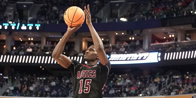 Mike Peake, #15 of the New Mexico State Aggies, takes a jump shot over Tyrese Martin, #4 of the Connecticut Huskies, during the first round game of the 2022 NCAA Men's Basketball Tournament at KeyBank Center on March 17, 2022 in Buffalo, New York.