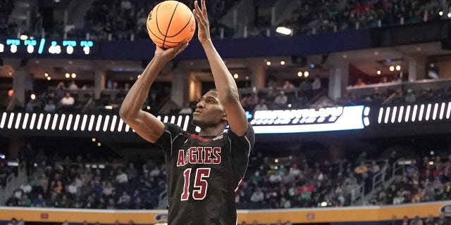 Mike Peake, #15 of the New Mexico State Aggies, takes a jump shot over Tyrese Martin, #4 of the Connecticut Huskies, during the first round game of the 2022 NCAA Men's Basketball Tournament at KeyBank Center on March 17, 2022 in Buffalo, New York.