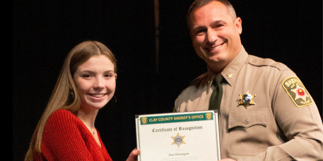 Clay County Sheriff Will Akin presents award to Ava Donegan. 