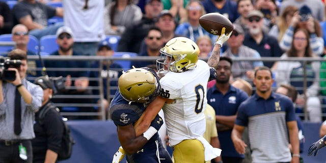 Notre Dame wide receiver Braden Lenzy (0) makes a touchdown catch behind the back of Navy cornerback Mbiti Williams, Jr. (7) during a game Nov. 12, 2022, at M and T Bank Stadium in Baltimore, Md.