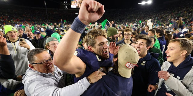 Michael Mayer #87 of the Notre Dame Fighting Irish celebrates with fans who stormed the field after defeating the Clemson Tigers 35-14 at Notre Dame Stadium on November 05, 2022 in South Bend, Indiana. 