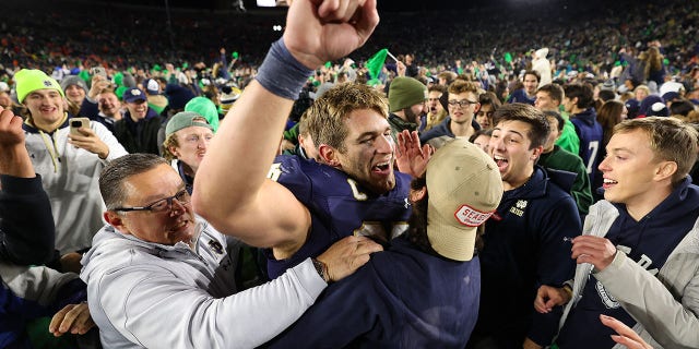 Michael Mayer #87 of the Notre Dame Fighting Irish celebrates with fans who stormed the field after defeating the Clemson Tigers 35-14 at Notre Dame Stadium on November 05, 2022 in South Bend, Indiana. 