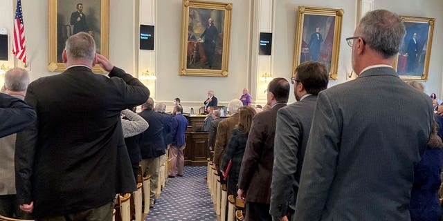 Members of the New Hampshire State House of Representatives salute the U.S. flag. The chamber neared an even split as votes were tabulated in November's midterm, though a recount remains underway.