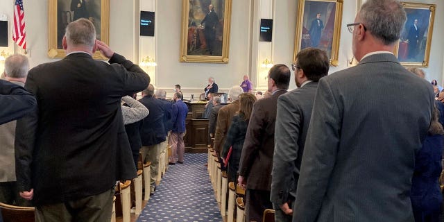 Members of the New Hampshire State House of Representatives salute the U.S. flag. The chamber neared an even split as votes were tabulated in November's midterm, though a recount remains underway.