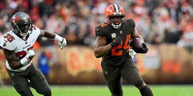 Nick Chubb (24) of the Cleveland Browns runs with the ball as Jamel Dean (35) of the Tampa Bay Buccaneers pursues during the second half at FirstEnergy Stadium Nov. 27, 2022, in Cleveland.