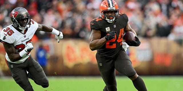 Nick Chubb (24) of the Cleveland Browns runs with the ball as Jamel Dean (35) of the Tampa Bay Buccaneers pursues during the second half at FirstEnergy Stadium Nov. 27, 2022, in Cleveland.